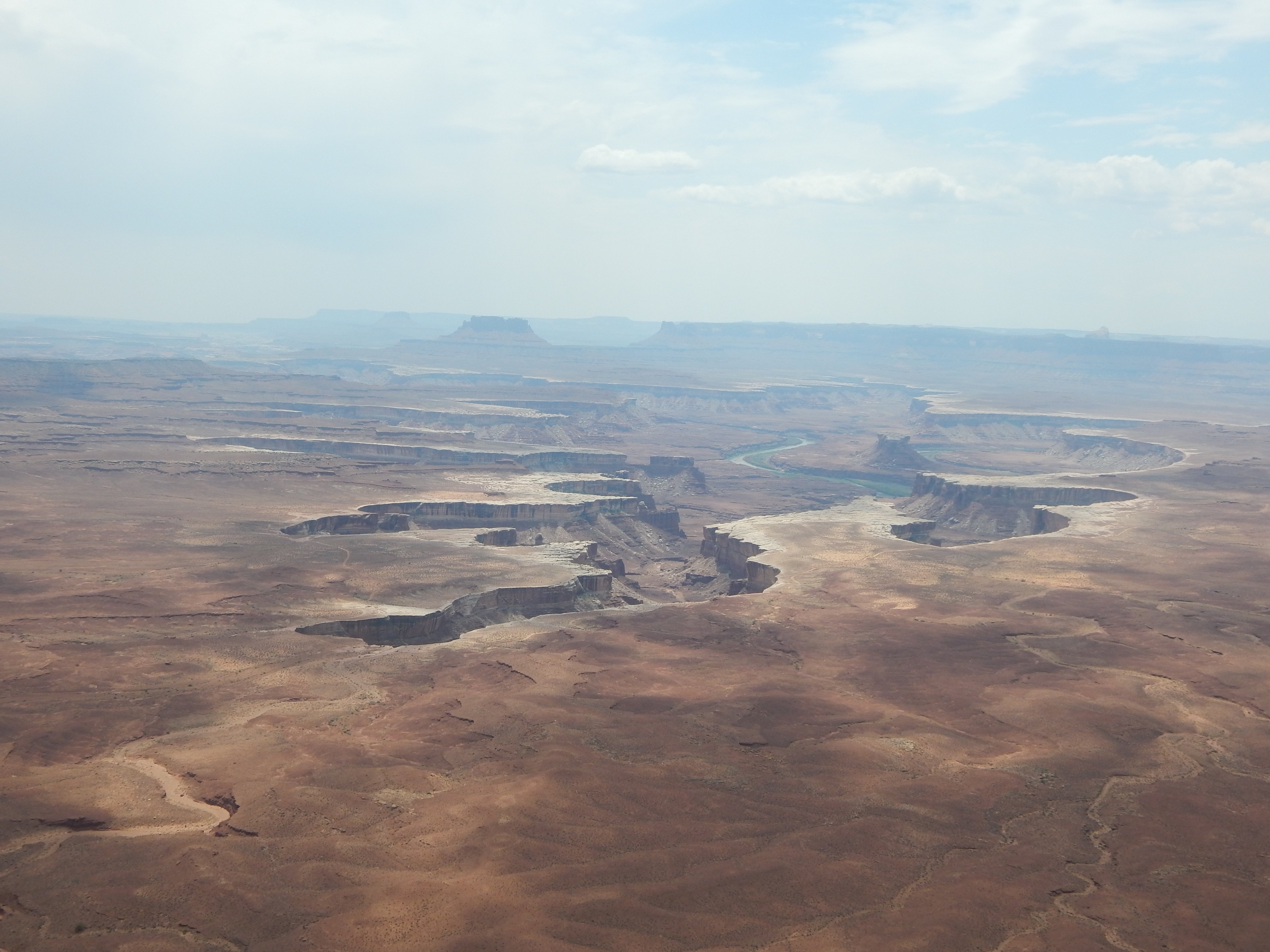 a canyon splitting off into small forks with a green river